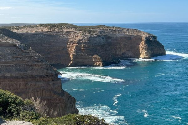 Powerful waves crashing against the cliffs, symbolizing the might of God.