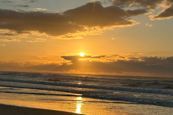 Wave rolling into ocean at Tallow Beach, symbolizing oneness with God