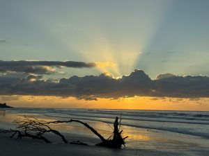 Soft light breaking through clouds over the ocean, symbolising spiritual truth emerging from moments of perceived failure.